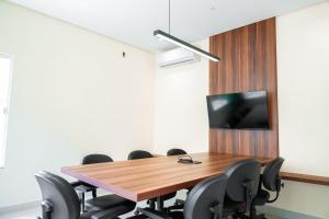 a conference room with a wooden table and chairs at Hotel Equinócios Express in Barcarena