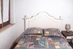 a bed with a quilt on it in a bedroom at Casa dos Cobertos in Terras de Bouro