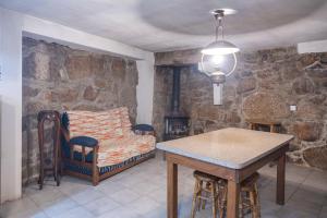 a room with a bed and a table and chairs at Casa dos Cobertos in Terras de Bouro