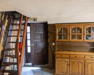 a staircase leading to a kitchen with wooden cabinets at Casa dos Cobertos in Terras de Bouro