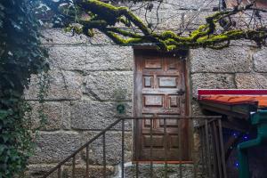 an old stone building with a wooden door at Casa dos Cobertos in Terras de Bouro