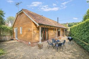a cabin with chairs and a grill in front of it at 2 Bed in Farnham oc-t34459 in Farnham
