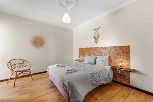 a bedroom with a bed and a chair in it at Cumbres Villa in Funchal