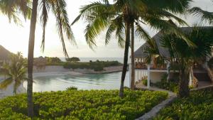 a house with palm trees in front of the ocean at Occidental at Xcaret Destination - All Inclusive in Playa del Carmen