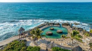 an aerial view of a swimming pool next to the ocean at Occidental at Xcaret Destination - All Inclusive in Playa del Carmen