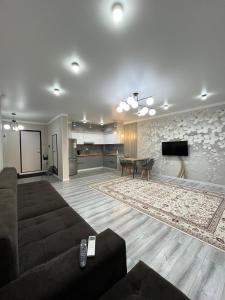 a living room with a couch and a dining room at ЖК City plus Евродвушка in Almaty