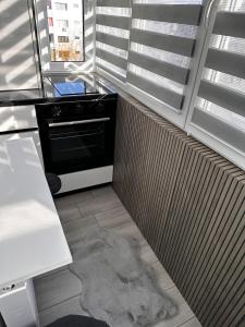 a kitchen with a stove and a rug on the floor at Angely Studio-balcon & parcare gratuită ,Self Check-in in Onești