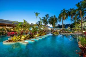 a pool at a resort with palm trees at Rafain Palace Hotel & Convention Center in Foz do Iguaçu