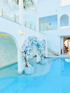 a room with blue flowers in vases on the floor at D'Blue Búzios Hotel Boutique in Búzios