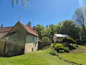 a house on a grassy hill next to a building at Le Moulin de serres in Bazoches