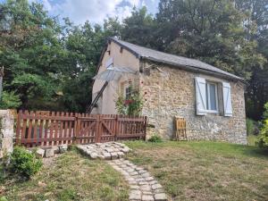 a stone house with a wooden fence in front of it at Le Moulin de serres in Bazoches +3 photos