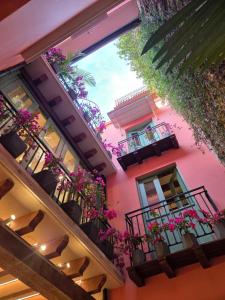 a building with flower boxes and balconies with flowers at Casa AcoModo at Casco Viejo 6BR Mansion w Pool in Panama City