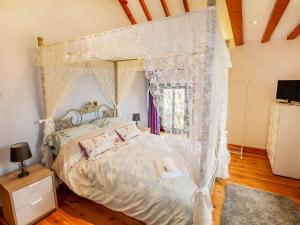 ein Schlafzimmer mit Himmelbett und Moskitonetzen in der Unterkunft Riber View Barn in Chesterfield