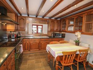 eine Küche mit Holzschränken und einem Tisch mit Stühlen in der Unterkunft Riber View Barn in Chesterfield