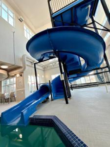 a blue slide in a room with a pool at Holiday Inn Express Airdrie by IHG in Airdrie