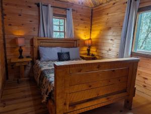 a bedroom with a bed in a log cabin at The Big Little Cabin - Hot Tub - Playground in Dahlonega