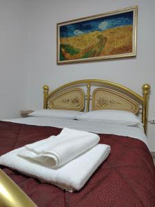 a bed with two white towels sitting on it at Villa Bazzera in Mestre