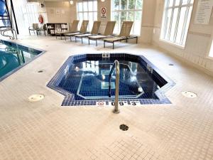 a swimming pool with a faucet in a building at Holiday Inn Express Airdrie by IHG in Airdrie