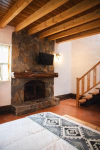 a stone fireplace in a room with a staircase at Hacienda Turistica Intihuatana in San Fernando