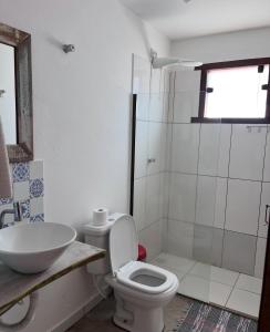 a bathroom with a toilet and a sink and a shower at Pousada das Estrelas in Itaúnas +24 photos