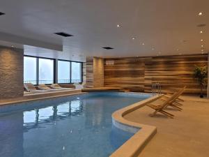 a pool in a hotel with chairs and a swimming pool at Prestige Lux Andan - Apart hotel Horizont Jahorina in Jahorina