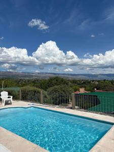 a swimming pool with a table and a chair at Complejo Alto Paraiso in Villa Cura Brochero
