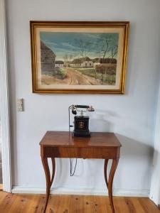 a clock on a table in a room with a painting at Inseldomizil Brummers Gaard in Haderslev