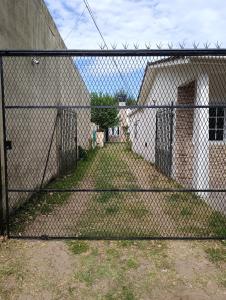 a chain link fence in front of a building at Mi casa querida in Mar de Ajó +3 photos