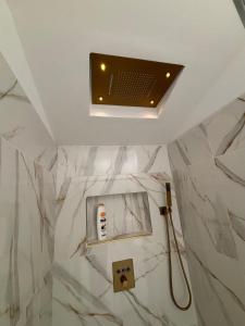 a bathroom with a shower with white marble walls at La Suite du Maine SAINTES in Saintes