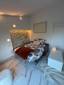 a bedroom with a bed and a stone wall at La Suite du Maine SAINTES in Saintes