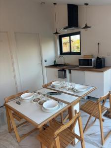 a kitchen with a table with plates on it at La Suite du Maine SAINTES in Saintes +4 photos