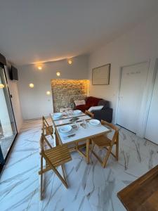 a living room with a table and chairs and a couch at La Suite du Maine SAINTES in Saintes
