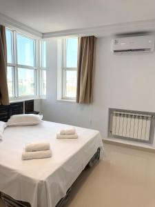 two beds in a hospital room with towels on them at Le charbon élégant in Bin Rhilouf