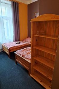 ein Schlafzimmer mit zwei Betten und einem Bücherregal in der Unterkunft Hotel Mrázek in Pardubice