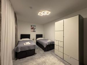 a bedroom with two beds and a cabinet in it at Glory's Apartment in Dußlingen