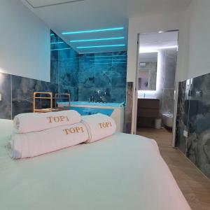 a bedroom with a large white bed with a bathroom at TOP1 Templum Luxuriae in Reggio di Calabria
