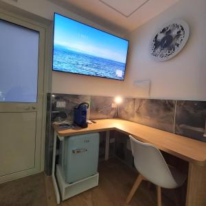 a computer desk with a television on a wall at TOP1 Templum Luxuriae in Reggio di Calabria