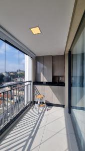 an apartment balcony with a chair and a view at Studio Comfort apartament Arujá in Arujá