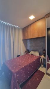 a bedroom with a bed and a table in it at Studio Comfort apartament Arujá in Arujá +6 photos