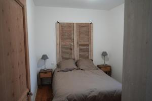 a bedroom with a bed and two lamps on two tables at Chez Rachel in Mérélessart
