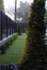 a christmas tree in a garden with a fence at Kalvokoresi 16 I Premium Apartments in Chios