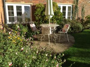 a table and chairs with an umbrella in a garden at Manor Farm in Poundon