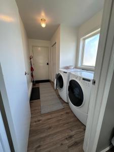 a laundry room with two washing machines and a window at Texada Hunter Hiker friendly suite in Vananda