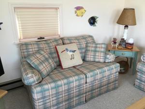 a couch with a pillow on it in a living room at Bayside Bliss in Dennis