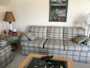 a living room with a couch and a table at Bayside Bliss in Dennis