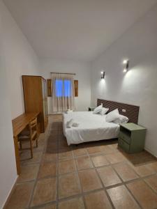 a bedroom with a bed and a desk in it at La Cilla Moratalla in Moratalla