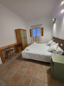 a bedroom with a bed and a desk and a window at La Cilla Moratalla in Moratalla +11 photos