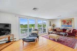 a living room with a couch and a tv at Le Petit Château in Dennis