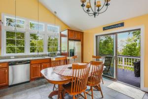 a kitchen with a table and chairs and a balcony at Pleasant Point in Wellfleet