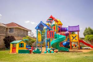 a playground with a slide in a yard at Grays Oak Hotel in Athi River